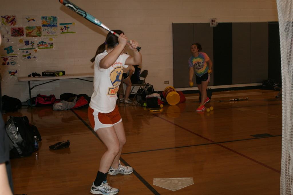 Varsity softball player Allison OHerron practices batting in the gym.