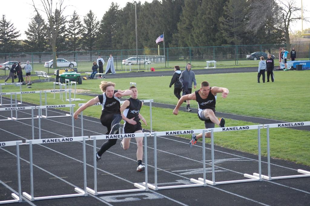Members of the boys track team soar over hurdles. Photo by Samantha Schrepferman.
