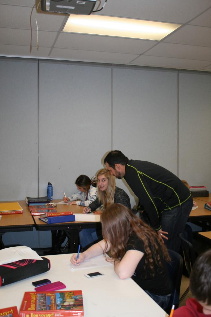 French teacher Andre Carriere helps a student with a question