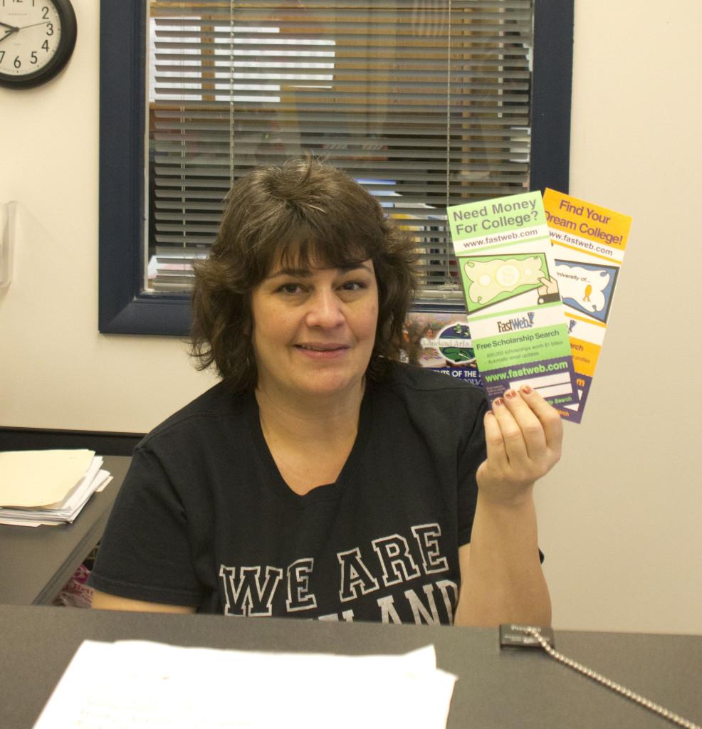Mrs. McPhee holds pamphlets containing scholarship information