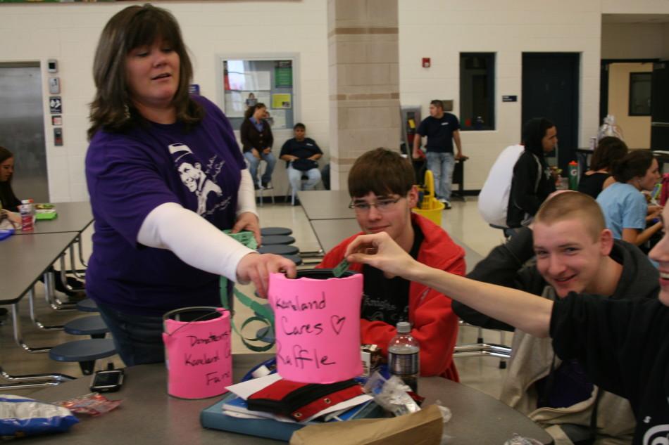Lori+Grant+encourages+students+to+donate+their+change+during+lunch.