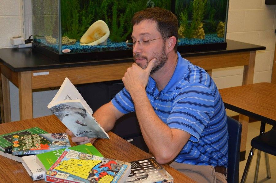 Science teacher Patrick Carter sits and ponders the subject matter of the book he is reading