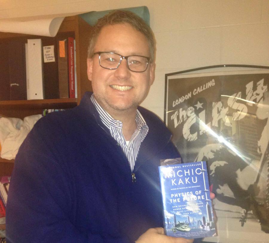 Kaneland High School social worker Patrick Trapp poses with his favorite book pick. 