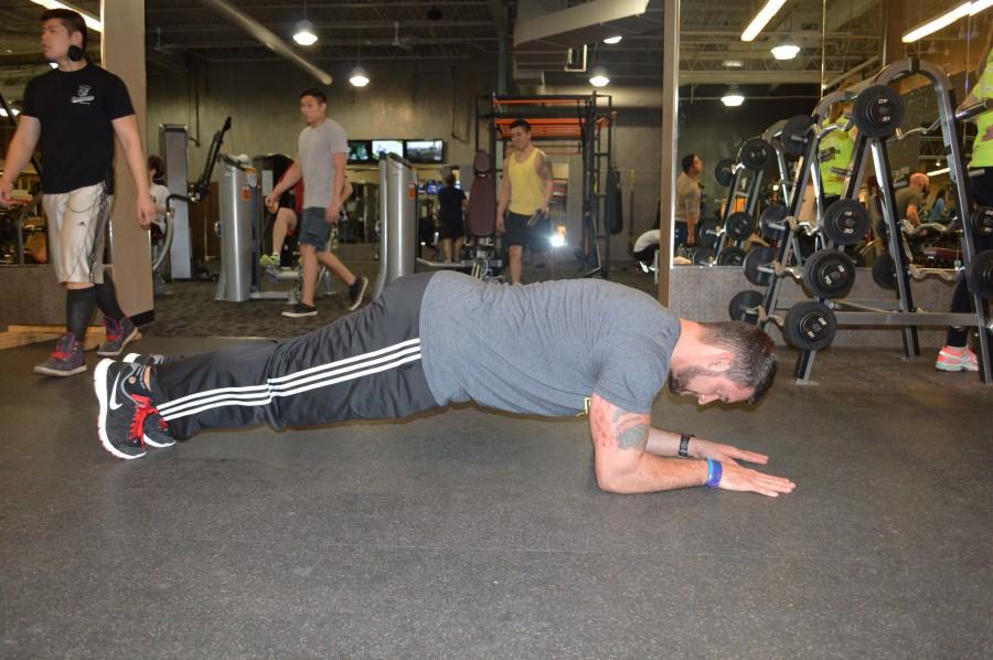 Campbell does plyo pushups by first getting into a regular pushup position. He puts his hands right next to each other on the ground, keeping his hands shoulder width apart. While squeezing his stomach and glute muscles and keeping a straight back, he bends his arms until his nose touches the floor.
