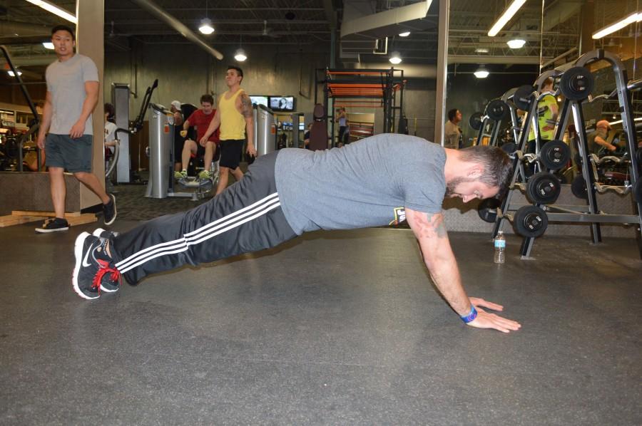 Campbell does plyo pushups by first getting into a regular pushup position. He puts his hands right next to each other on the ground, keeping his hands shoulder width apart. While squeezing his stomach and glute muscles and keeping a straight back, he bends his arms until his nose touches the floor.
