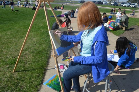 A student enjoys painting a city while outside.