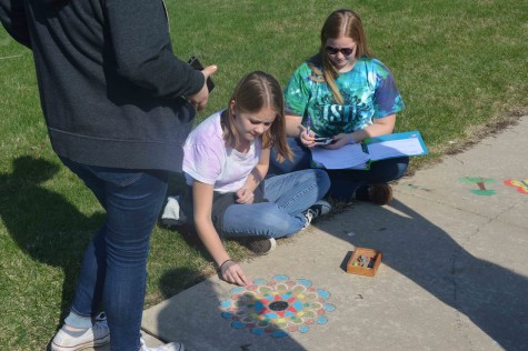 Students enjoy creating art on the sidewalk.