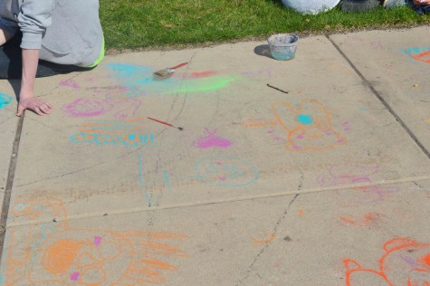Art is displayed on the sidewalk of the A Hallway entrance.