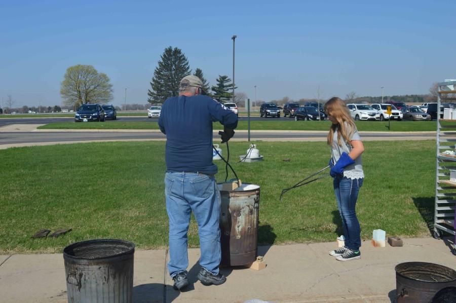Freshman Emma Fuger helps create a more natural way of burning clay.