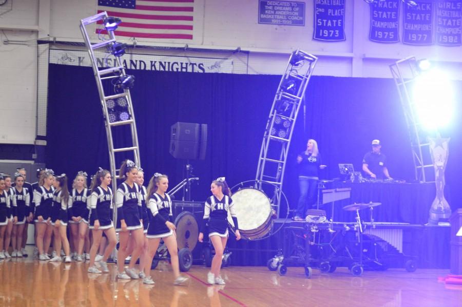 The cheerleaders make their way out to the center of the gym. 