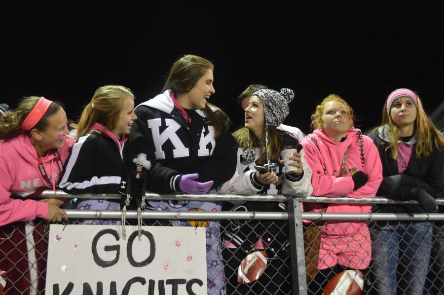 Seniors think pink as they line the fence at the varsity football game.