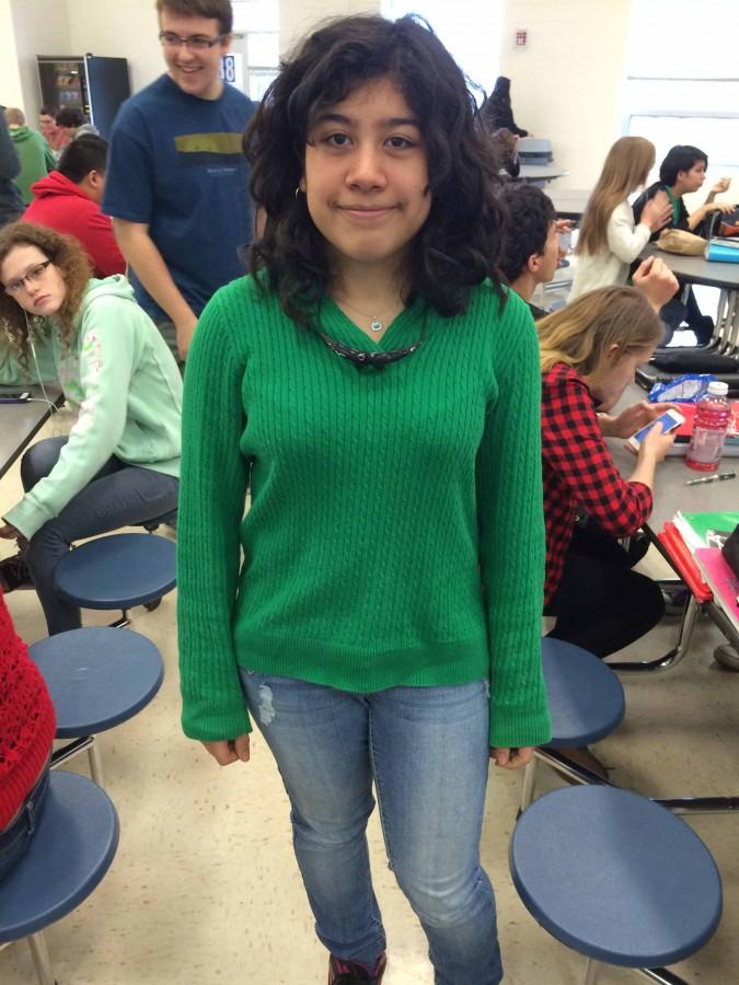 Sophomore Valencia Baez takes a break from chatting with friends in the lunchroom to pose for a picture showing off her green sweater.