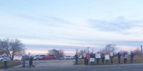 Teachers hold picket signs Friday morning
