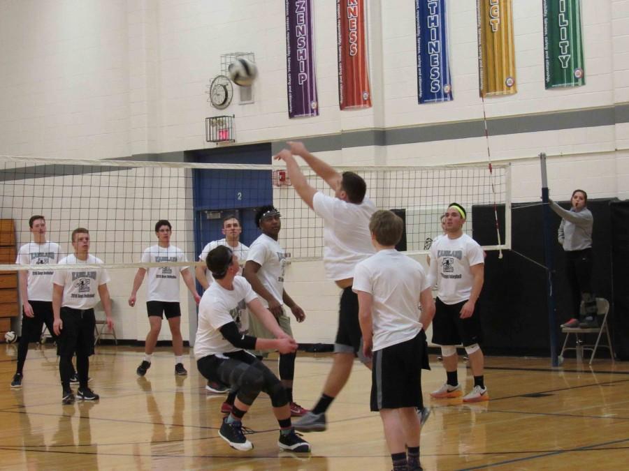 Boys showcase their volleyball skills as they toss the ball over the net.