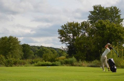 Senior Will Marshall takes a swing at Hughes Golf Course.