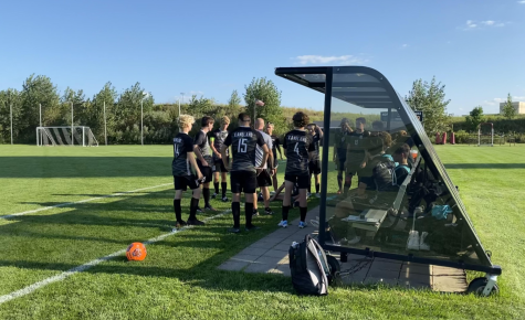 The varsity soccer players gather during halftime to prepare for the second half. The players like to converse to get on the same page before going back out on the field.