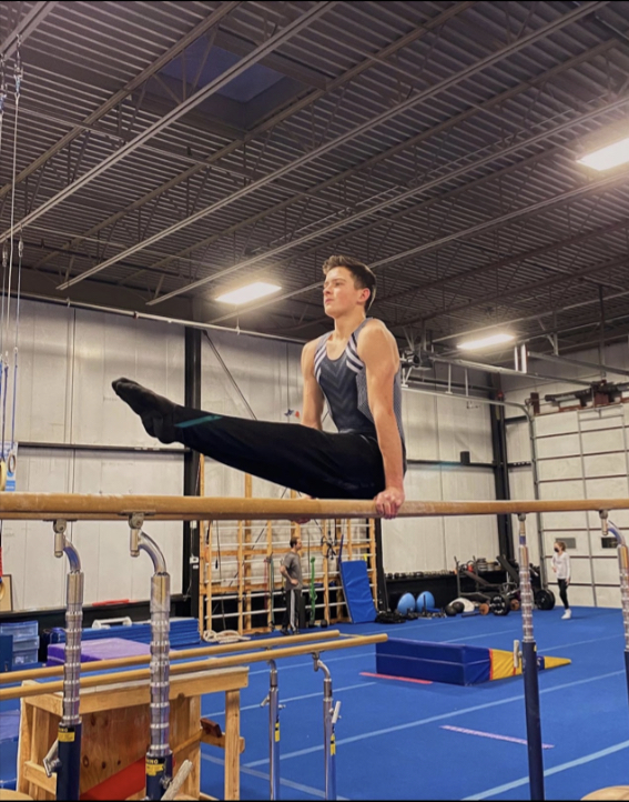 Junior Ethan Yost practices a strengthening skill on the parallel bars at Excel Gymnastics Academy in Geneva. Yost has attended Excel for 10 years and currently coaches several classes for younger students. 