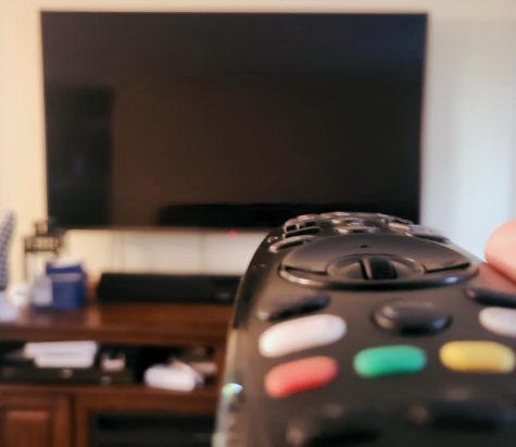 A remote is pointed at the TV screen in front of it. HBO Max, a popular streaming service, is making a lot of upcoming changes to its platform. 