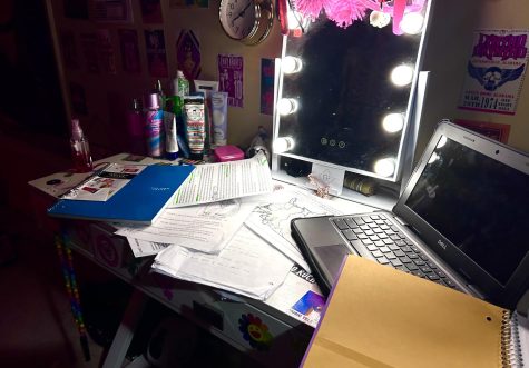 Many different assignments are piled up on a desk. Handling a lot of schoolwork can be an anxiety-inducing task for many students. 