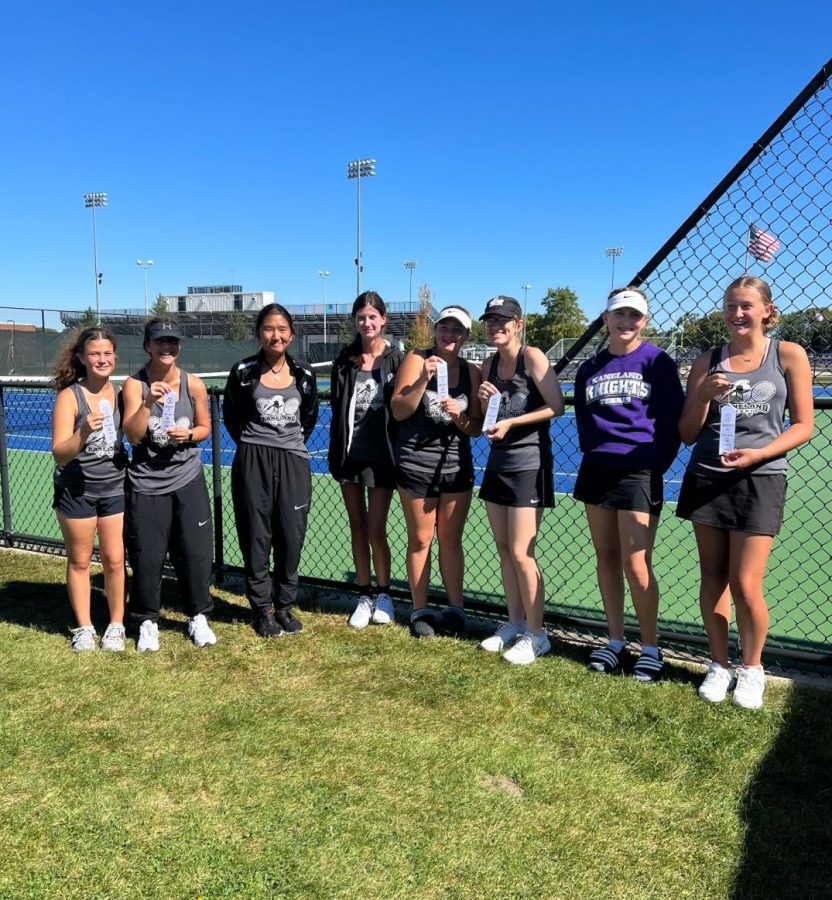 The+junior+varsity+tennis+team+stands+together+to+show+off+their+ribbons.+The+team+got+fourth+place+overall+at+their+conference+tournament.