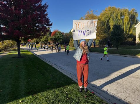 Junior Jessica Wrobel cheers on runners as they complete the 5k run. Wrobel attended the event to complete her National Honor Society volunteering hours.
