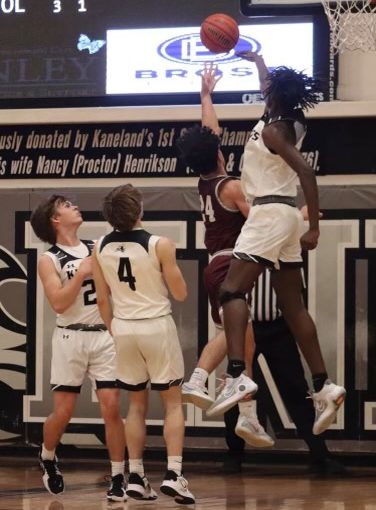 Sophomore center Freddy Hassan blocks the shot of an Elgin player as he tries to score in the lane. Hassan had a team-leading four blocks in the Knights victory over the Maroons. 