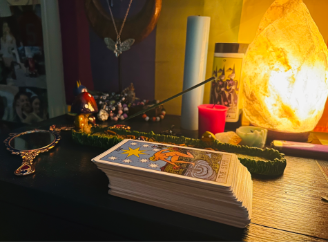 Tarot cards and an incense burner lay on a bedside table. Tarot cards can be cleansed with incense smoke before being used.