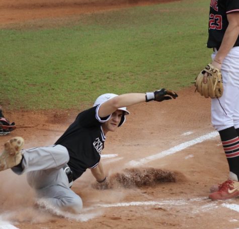 Senior Alex Panico is safe as he slides into home plate. The varsity baseball and softball teams traveled to Gulf Shores, AL, for tournaments during Spring Break. (Photo courtesy of Grace Collins)
