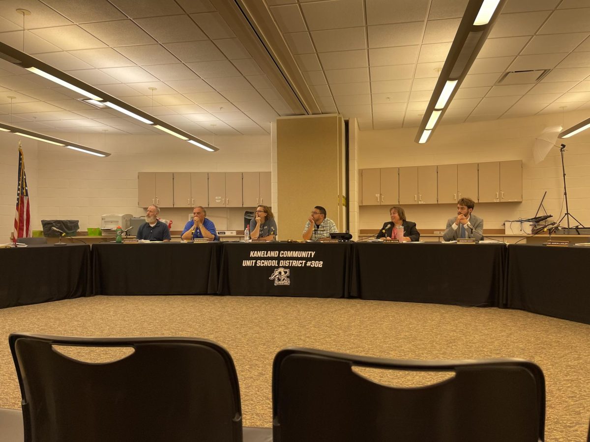 Members of the school board listen to Director of Educational Services 6-12 Patrick Raleigh present updates to the Kaneland Connects strategic plan and the School Improvement Plan. The purpose of the presentation was to provide updates from last year and explain plans for the coming year. 
