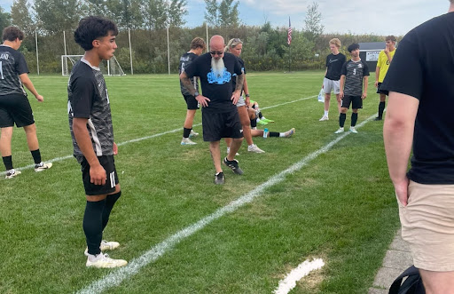 Head coach Scott Parillo talks to the boys soccer team at halftime about their performance in the previous half. Parillo and the boys both are disappointed with their performance and the outcome of the half (leading only by 3-1); they got  water, talked  and gave each other  advice before getting back out on the field to finish the game.