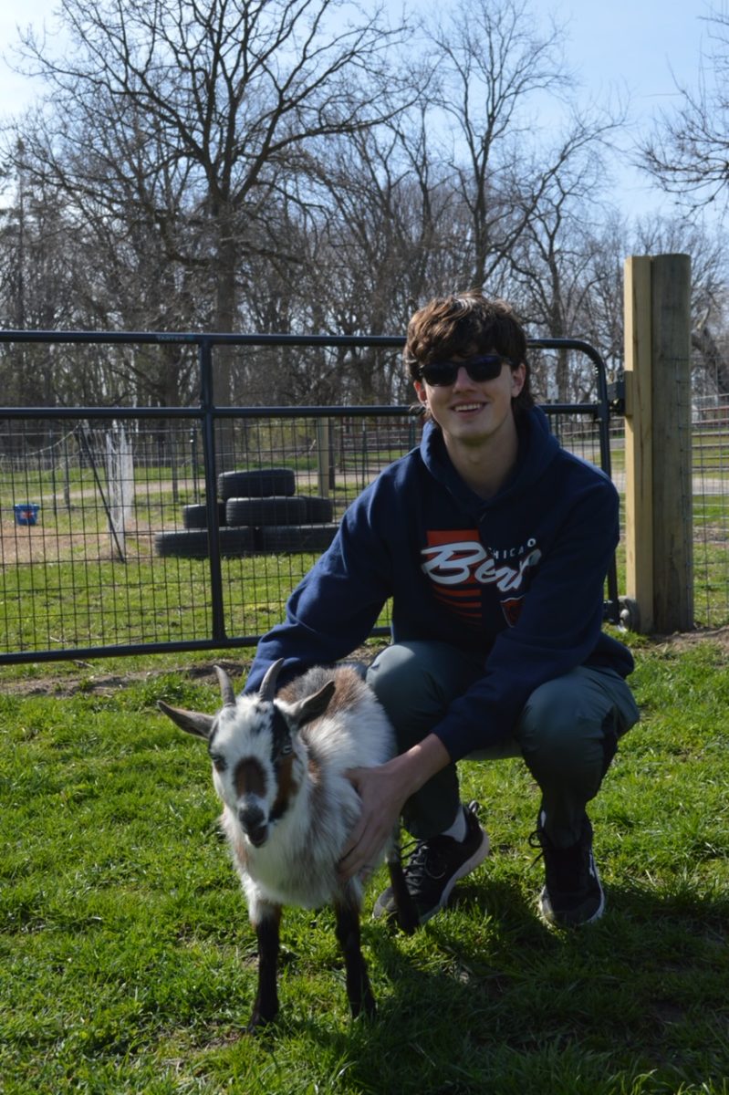 Senior Hudson Warfel poses with one of his six goats, Pebbles. One-year-old Pebbles and her brother are the first goats his family got. 