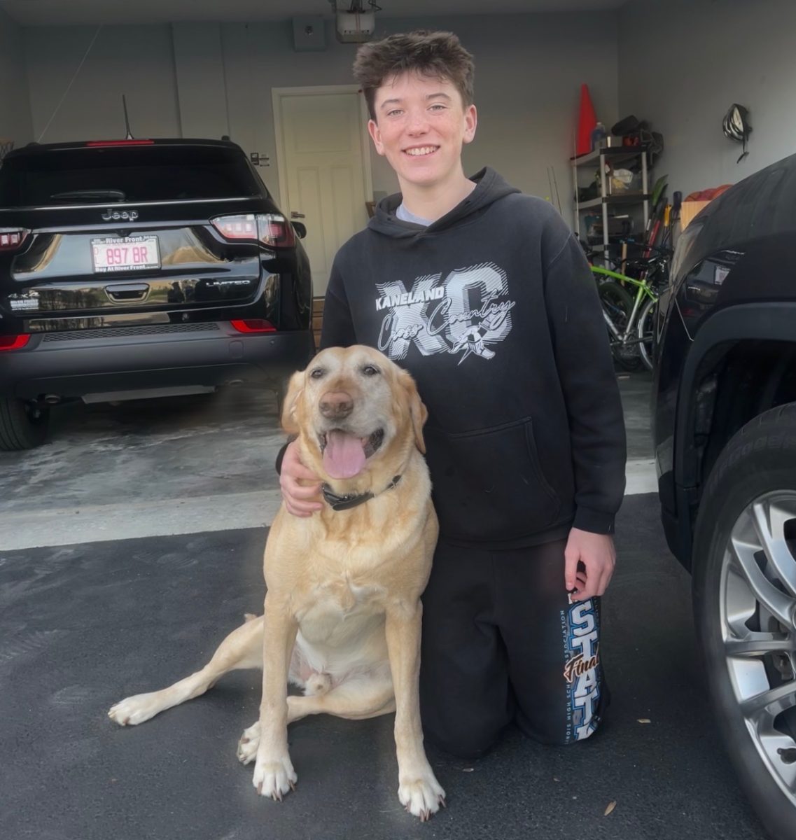 Sophomore Grant Caston stands next to his Labrador Retriever, Odin. They enjoy going on hikes and walks together.